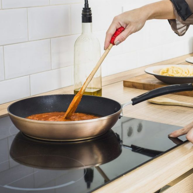 person mixing sauce pan stove 1200x675 1