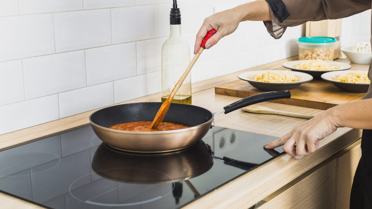person mixing sauce pan stove 1200x675 1