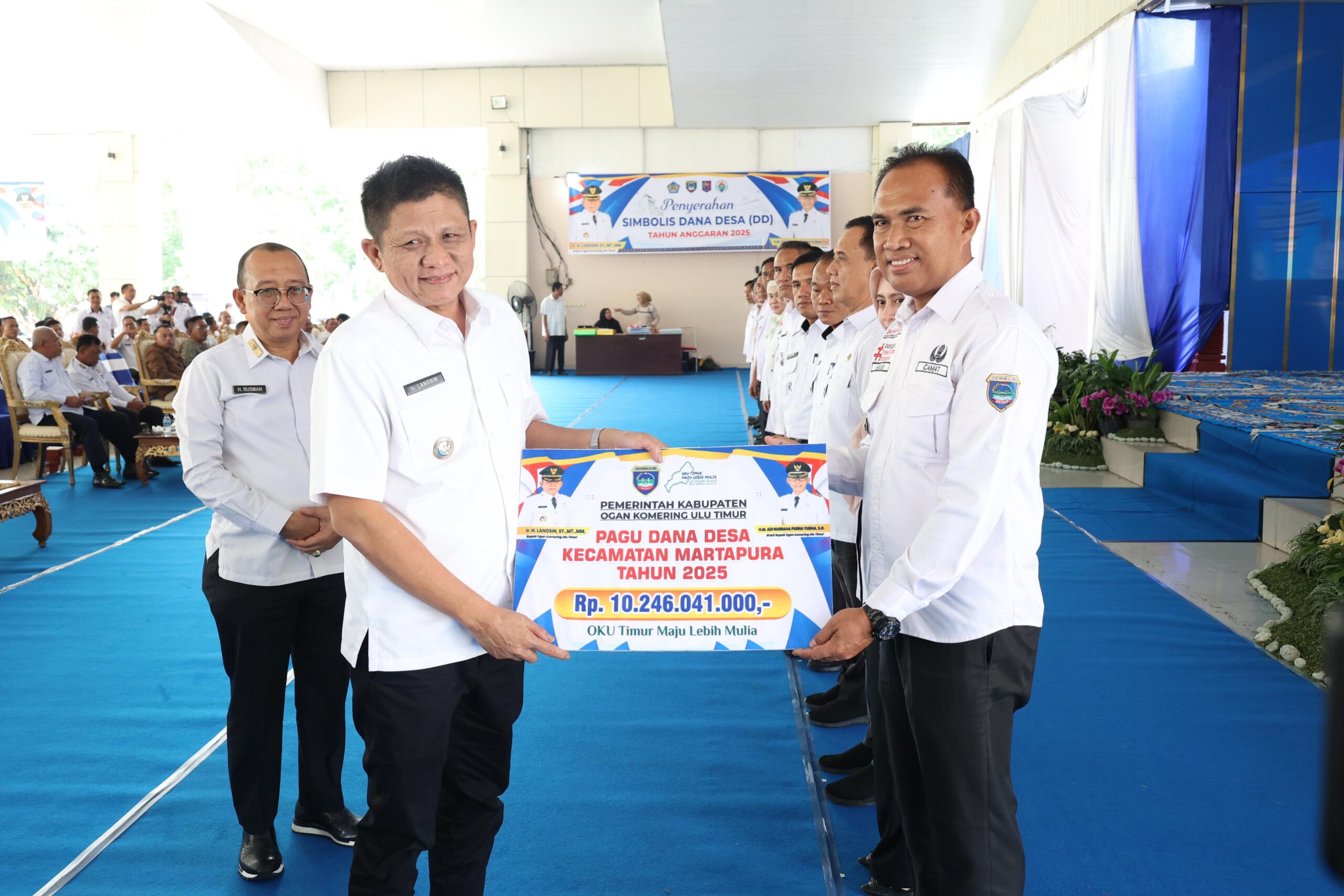 Bupati OKU Timur Lanpsin secara simbolis menyerahkan Dana Desa Tahun Anggaran 2025 kepada Kepala Desa.