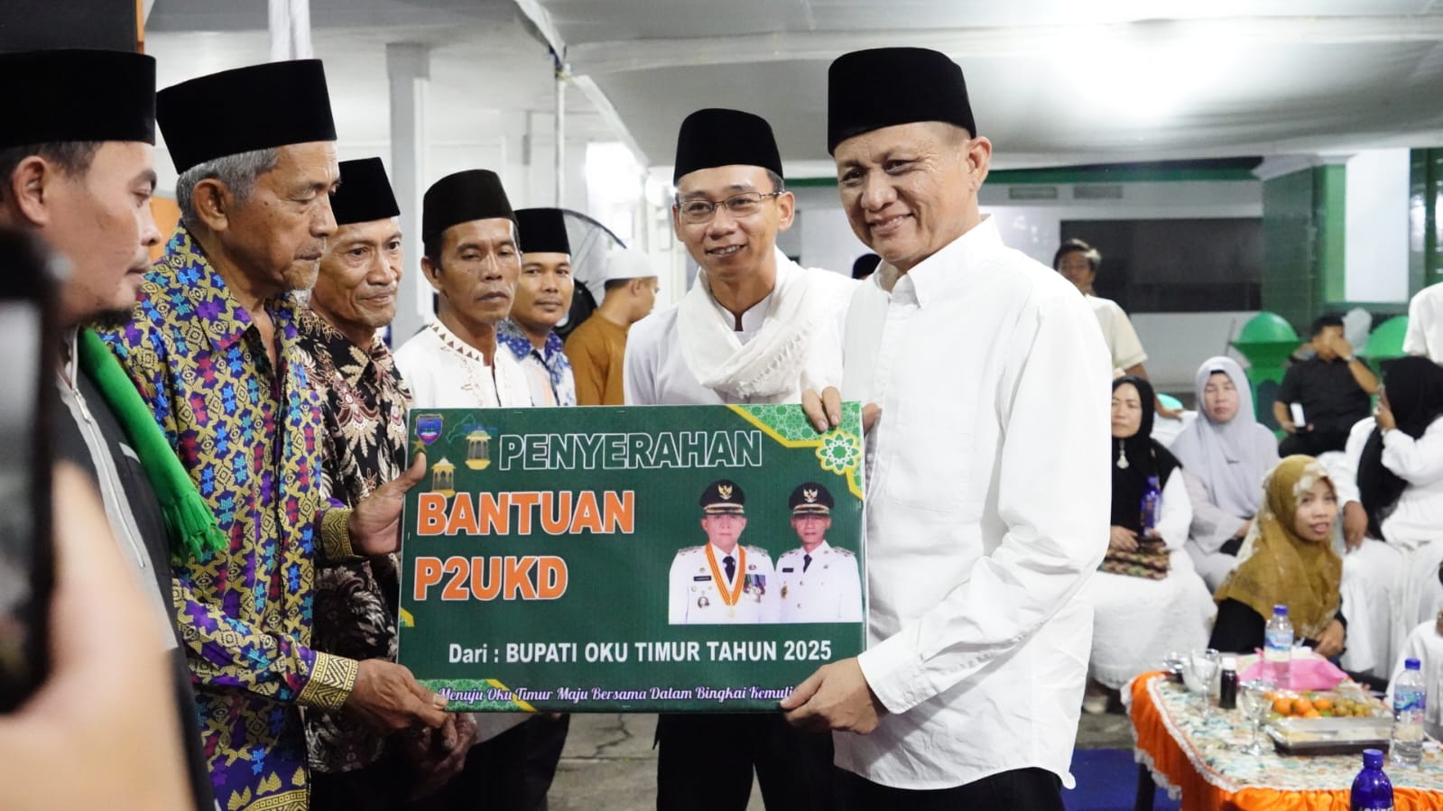 Bupati dan Wakil Bupati OKU Timur Lanosin - Yudha menyerahkan hadiah umroh dan bantuan masjid.