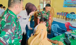 Bhabinkamtibmas Polsek Buay Madang Timur (BMT) Bripka Corry Syamsuarni bersama Babinsa Koramil Buay Madang memberikan suport kepada para siswa yang mengikuti cek kesehatan gratis dan BIAS.