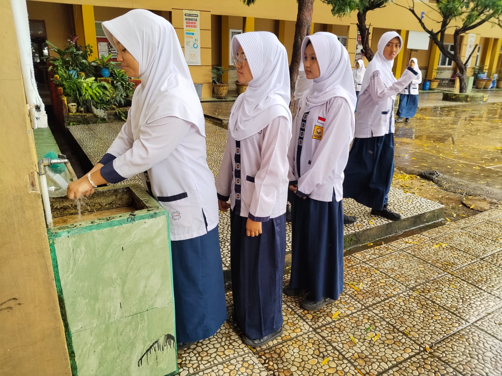 Siswi SMP 45 yang Tengah mencuci tangan dengan memakai air hasil olahan alat konservasi Air. 