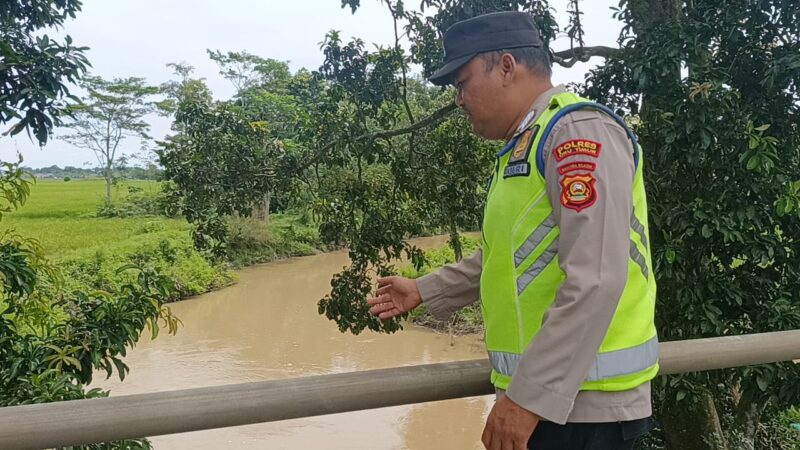 Personel sedang menunjuk ke arah aliran air sungai. 