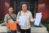 Saat  korban Dedi Irawan yang didampingi tim penasihat hukumnya Achmad Azhari SH menunjukkan surat tanda penerimaan laporan di SPKT Polda Sumsel , Jumat (13/3/2026)