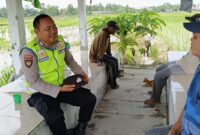Bripka Nur Holik, personil Polsek Buay Madang Timur, saat berdialog akrab dengan warga Desa Pengandonan. 