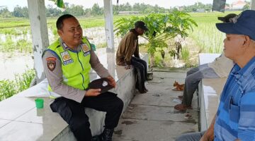 Bripka Nur Holik, personil Polsek Buay Madang Timur, saat berdialog akrab dengan warga Desa Pengandonan. 