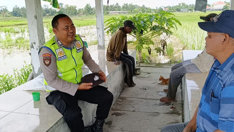 Bripka Nur Holik, personil Polsek Buay Madang Timur, saat berdialog akrab dengan warga Desa Pengandonan. 