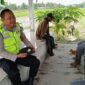 Bripka Nur Holik, personil Polsek Buay Madang Timur, saat berdialog akrab dengan warga Desa Pengandonan. 