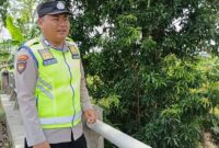 Bripka Nur Holik memantau kondisi Sungai Macak di Desa Sukoharjo, Buay Madang Timur. 