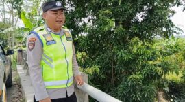 Bripka Nur Holik memantau kondisi Sungai Macak di Desa Sukoharjo, Buay Madang Timur. 