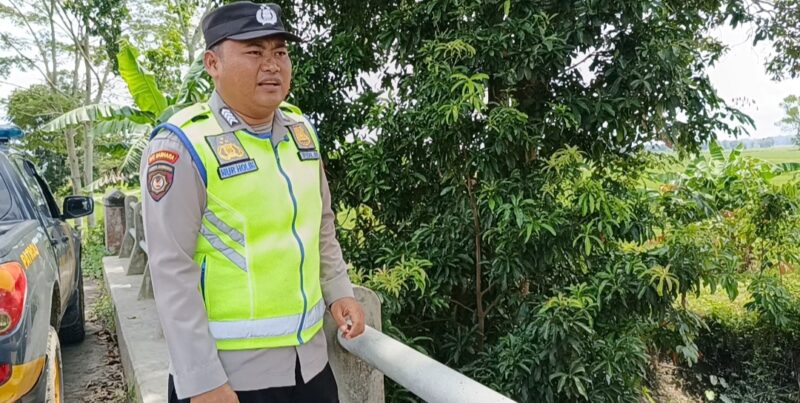 Bripka Nur Holik memantau kondisi Sungai Macak di Desa Sukoharjo, Buay Madang Timur. 