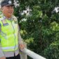 Bripka Nur Holik memantau kondisi Sungai Macak di Desa Sukoharjo, Buay Madang Timur. 