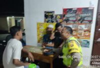 Personel Polsek Buay Madang Timur, Bripka Nurholik, berdialog santai dengan warga Desa Sukoharjo saat melaksanakan patroli sambang. 