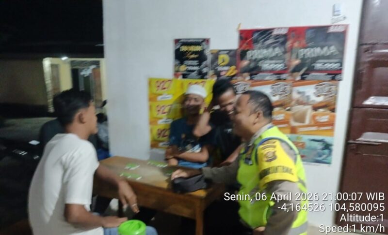 Personel Polsek Buay Madang Timur, Bripka Nurholik, berdialog santai dengan warga Desa Sukoharjo saat melaksanakan patroli sambang. 