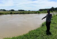 Pastikan situasi tetap kondusif, Personel Polsek Buay Madang Timur melaksanakan monitoring debit air di Sungai Macak, Desa Kedu. 