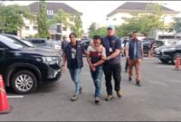 Tersangka R (36) saat tiba di Polda Sumsel, Senin (13/4/2026) sore.