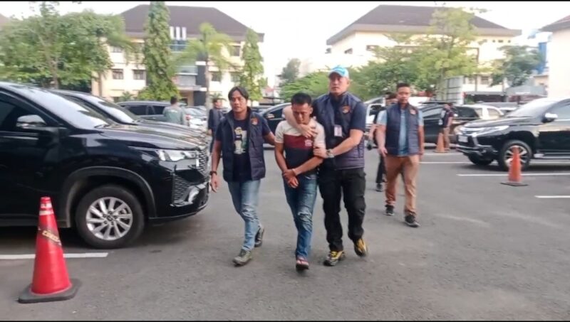 Tersangka R (36) saat tiba di Polda Sumsel, Senin (13/4/2026) sore.