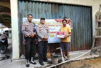 Kapolsek Buay Madang Timur, IPTU Swisspo (tengah), secara simbolis menyerahkan paket sembako kepada salah satu warga penerima manfaat di wilayah Buay Madang Timur. 