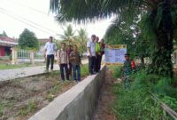 Kapolsek Buay Madang Timur, Iptu Swisspo, bersama unsur Tripika Kecamatan meninjau langsung hasil pembangunan Tembok Penahan Tanah (TPT) di Desa Tekorejo. 