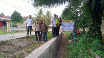 Kapolsek Buay Madang Timur, Iptu Swisspo, bersama unsur Tripika Kecamatan meninjau langsung hasil pembangunan Tembok Penahan Tanah (TPT) di Desa Tekorejo. 