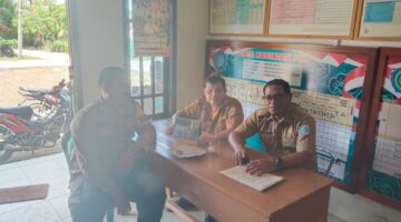 Bhabinkamtibmas Polsek Buay Madang Timur, Bripka Berlin Mandala (kiri), sedang berdialog dengan perangkat desa saat kegiatan sambang dan silaturahmi di Kantor Desa Metro Rejo, OKU Timur. 