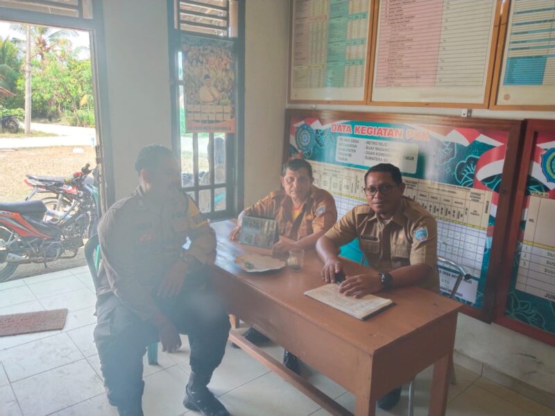 Bhabinkamtibmas Polsek Buay Madang Timur, Bripka Berlin Mandala (kiri), sedang berdialog dengan perangkat desa saat kegiatan sambang dan silaturahmi di Kantor Desa Metro Rejo, OKU Timur. 
