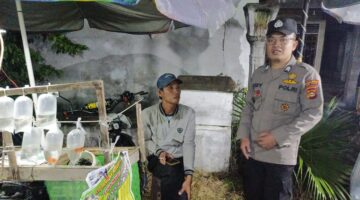 Brigadir Tedy Heryadi, personel Polsek Buay Madang Timur, berdialog dengan seorang pedagang ikan hias saat melaksanakan giat sambang di Desa Sumber Asri, OKU Timur. 
