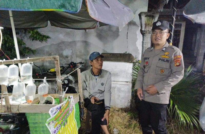 Brigadir Tedy Heryadi, personel Polsek Buay Madang Timur, berdialog dengan seorang pedagang ikan hias saat melaksanakan giat sambang di Desa Sumber Asri, OKU Timur. 