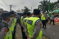 Kapolsek Buay Madang Timur Iptu Swisspo tengah memberikan arahan kepada personel gabungan Polres OKU Timur dan Polsek jajaran dalam apel kesiapan pengamanan Pengajian Akbar di Desa Sumber Harjo. 