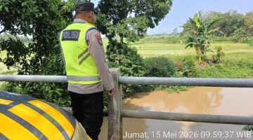 Personel Polsek Buay Madang Timur memantau ketinggian debit air di Sungai Macak, Desa Sukoharjo, Kecamatan Buay Madang Timur, Kabupaten OKU Timur. 