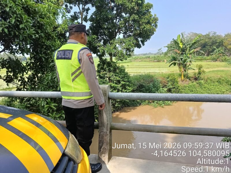 Personel Polsek Buay Madang Timur memantau ketinggian debit air di Sungai Macak, Desa Sukoharjo, Kecamatan Buay Madang Timur, Kabupaten OKU Timur. 