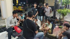 Sejumlah remaja pelaku balap liar terduduk lemas saat didata oleh petugas kepolisian di halaman Mapolsek Buay Madang Timur, OKU Timur, Sumatera Selatan.