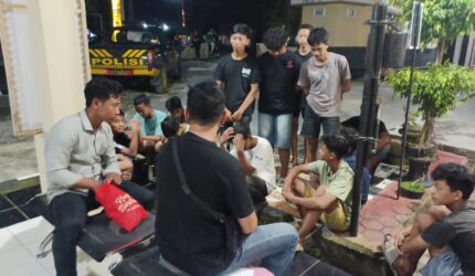 Sejumlah remaja pelaku balap liar terduduk lemas saat didata oleh petugas kepolisian di halaman Mapolsek Buay Madang Timur, OKU Timur, Sumatera Selatan.