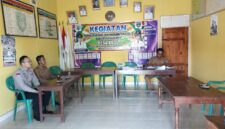 Personel Polsek Buay Madang Timur, Brigadir Tedy Heryadi (kiri), berdialog dengan perangkat desa saat menggelar kegiatan sambang di Kantor Desa Kedu, Kecamatan Buay Madang Timur, Kabupaten OKU Timur, Sumatera Selatan.