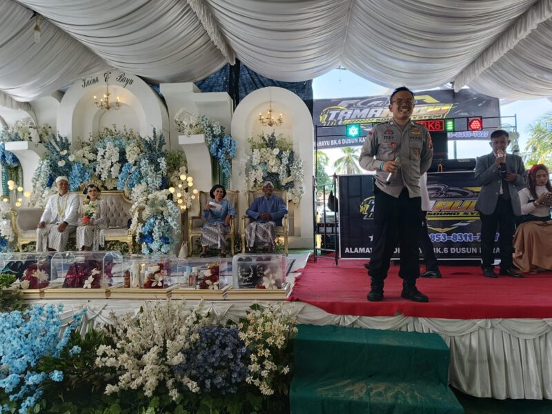 Bhabinkamtibmas Polsek Buay Madang Timur, Brigadir Tedy Heryadi, saat menyampaikan imbauan larangan pemutaran musik remix, house music, dan DJ dari atas panggung pesta pernikahan di Kumpul Rejo, Kecamatan Buay Madang Timur, Kabupaten OKU Timur, Sumatera Selatan. 