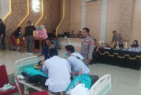Personel Polsek Buay Madang Timur memantau jalannya proses medis saat mendampingi anak-anak peserta khitanan massal di Aula Polres OKU Timur, Sumatera Selatan. 