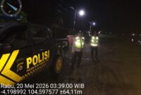 Personel Polsek Buay Madang Timur berdiri di samping mobil dinas patroli saat melaksanakan Kegiatan Rutin Yang Ditingkatkan (KRYD) di Jalan Desa Kedung Rejo, Kecamatan Buay Madang Timur, Kabupaten OKU Timur, Sumatera Selatan. 