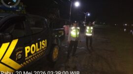 Personel Polsek Buay Madang Timur berdiri di samping mobil dinas patroli saat melaksanakan Kegiatan Rutin Yang Ditingkatkan (KRYD) di Jalan Desa Kedung Rejo, Kecamatan Buay Madang Timur, Kabupaten OKU Timur, Sumatera Selatan. 