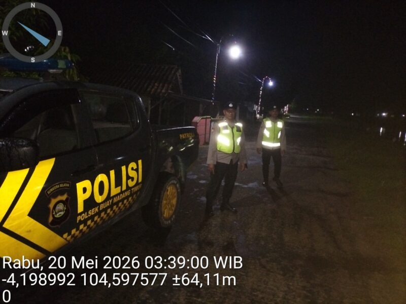 Personel Polsek Buay Madang Timur berdiri di samping mobil dinas patroli saat melaksanakan Kegiatan Rutin Yang Ditingkatkan (KRYD) di Jalan Desa Kedung Rejo, Kecamatan Buay Madang Timur, Kabupaten OKU Timur, Sumatera Selatan. 
