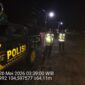 Personel Polsek Buay Madang Timur berdiri di samping mobil dinas patroli saat melaksanakan Kegiatan Rutin Yang Ditingkatkan (KRYD) di Jalan Desa Kedung Rejo, Kecamatan Buay Madang Timur, Kabupaten OKU Timur, Sumatera Selatan. 