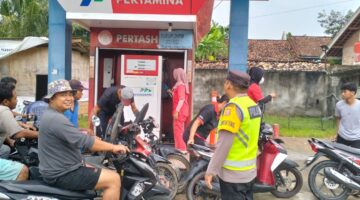 Personel Polsek Buay Madang Timur yang dipimpin oleh Kapolsek Iptu Swisspo, memantau antrean pengendara sepeda motor saat membeli BBM di Pertashop Desa Pengandonan, Kecamatan Buay Madang Timur, Kabupaten OKU Timur, Sumatera Selatan.