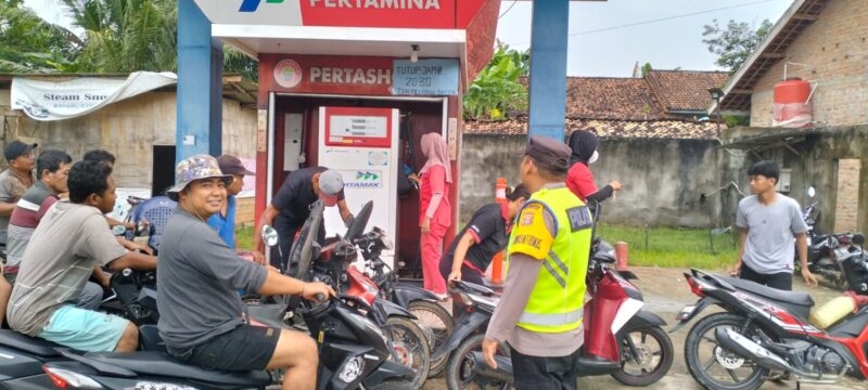 Personel Polsek Buay Madang Timur yang dipimpin oleh Kapolsek Iptu Swisspo, memantau antrean pengendara sepeda motor saat membeli BBM di Pertashop Desa Pengandonan, Kecamatan Buay Madang Timur, Kabupaten OKU Timur, Sumatera Selatan. 