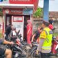 Personel Polsek Buay Madang Timur yang dipimpin oleh Kapolsek Iptu Swisspo, memantau antrean pengendara sepeda motor saat membeli BBM di Pertashop Desa Pengandonan, Kecamatan Buay Madang Timur, Kabupaten OKU Timur, Sumatera Selatan. 