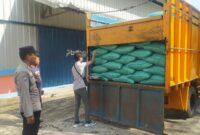 Personel Polsek Buay Madang Timur memantau proses pemeriksaan karung-karung berisi hasil panen jagung di bak truk sebelum diturunkan ke Gudang Bulog Sungai Tuha, Kecamatan Martapura, OKU Timur. 