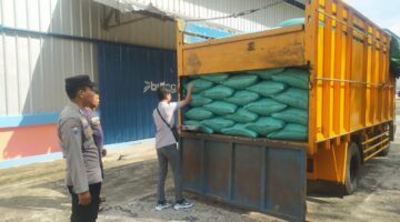 Personel Polsek Buay Madang Timur memantau proses pemeriksaan karung-karung berisi hasil panen jagung di bak truk sebelum diturunkan ke Gudang Bulog Sungai Tuha, Kecamatan Martapura, OKU Timur. 