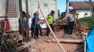 Kapolsek Buay Madang Timur Iptu Swisspo, (kanan) memindahkan material batu bata bersama warga dan Takmir Masjid Al Amin saat meninjau pembangunan sumur bor dan MCK di Desa Berasan Mulya, Kecamatan Buay Madang Timur, Kabupaten OKU Timur. 