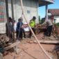 Kapolsek Buay Madang Timur Iptu Swisspo, (kanan) memindahkan material batu bata bersama warga dan Takmir Masjid Al Amin saat meninjau pembangunan sumur bor dan MCK di Desa Berasan Mulya, Kecamatan Buay Madang Timur, Kabupaten OKU Timur. 