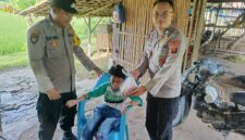 Bhabinkamtibmas Polsek Buay Madang Timur Bripka Nur Holik (kiri) bersama Brigadir Tedy Heryadi (kanan) menyerahkan paket daging kurban dari Kapolres OKU Timur kepada salah satu anak penyandang disabilitas di Desa Pengandonan, Kecamatan Buay Madang Timur, Kabupaten OKU Timur, Sumatera Selatan. 