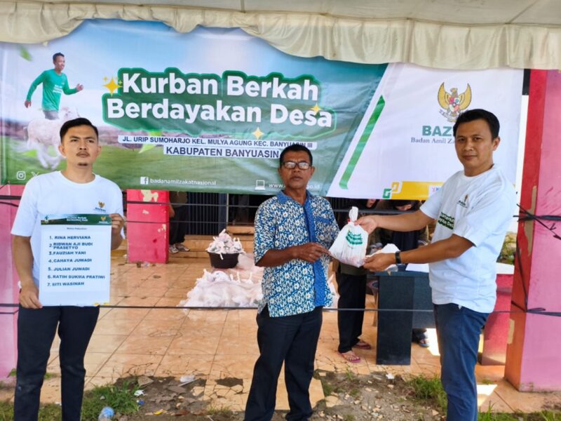 CAPTION FOTO : SERAH TERIMA SIMBOLIK - Badan Amil Zakat Nasional (BAZNAS) Kabupaten Banyuasin secara simbolik menyerahkan daging kurban untuk ratusan warga di Banyuasin, menjalankan Amanah dari BAZNAS RI untuk melaksanakan penyembelihan dan pendistribusian hewan kurban melalui program nasional Kurban Berkah Berdayakan Desa, Kamis (28/5/2026).