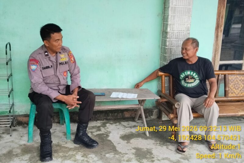 Anggota Polsek Buay Madang Timur, Aiptu Sahrul Munir (kiri), berbincang dengan seorang warga saat melaksanakan kegiatan sambang kamtibmas di Desa Sumber Asri, Kecamatan Buay Madang Timur, Kabupaten OKU Timur. 